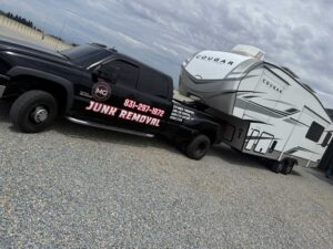 Home 26 Black truck parked next to trailer, representing same-day hauling capabilities in Hollister.