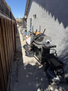 Residential yard with accumulated junk items staged for removal