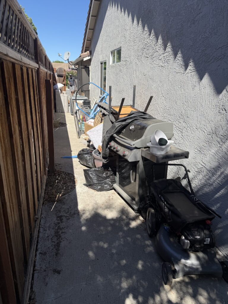 Items That Look Simple to Haul and Aren't: A Gilroy Homeowner's Reality Check 13 Residential yard with accumulated junk items staged for removal